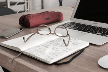 finansieringssystem bild på glasögon, papper och ett anteckningsblock